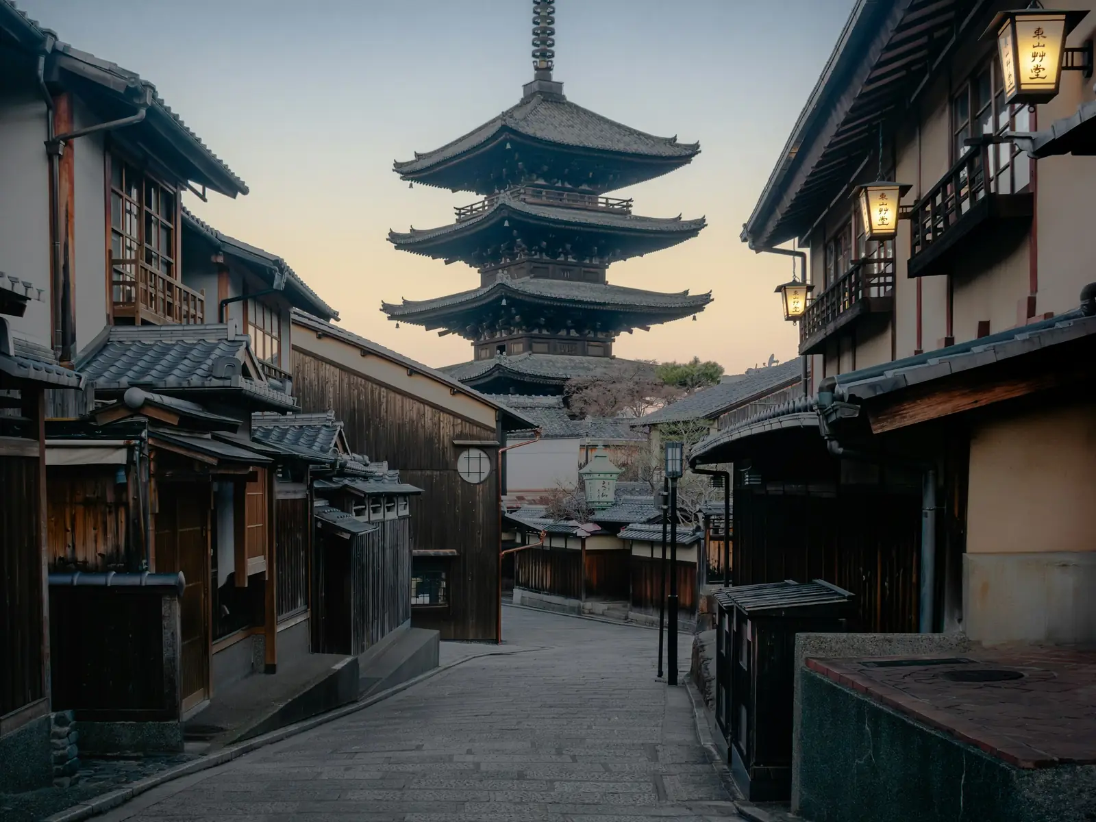 An empty early-morning street in the Higashiyama district of Kyoto, with the Yasaka Pagoda beyond the machiya rooftops